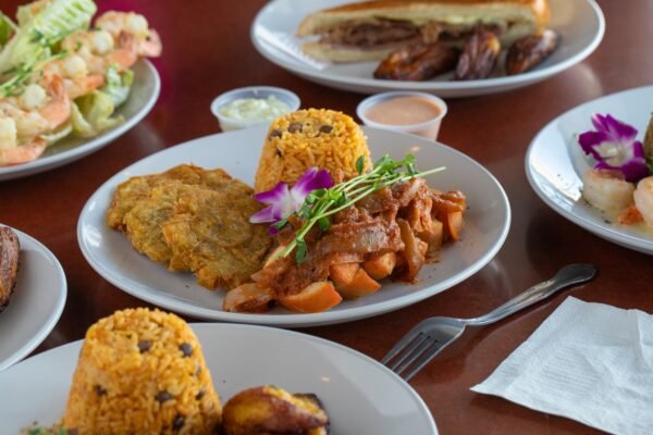 several plates of food are on a table as people are eating
